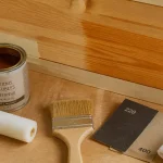 Vernissage meuble bois : surface fraîchement vernie sur bois poncé